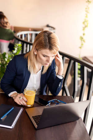 Business woman in cafe with business plan. Beautiful girl is working on laptop. Business and lifestyle concept.の写真素材
