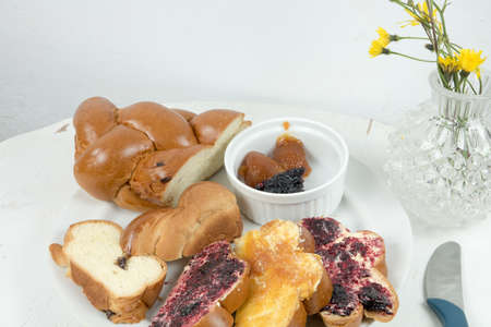 Christmas bakery with butter and homemade jam. Slovakia traditional christmas bread. Sweet bakery ideal for breakfast. Served on old vintage wooden table and with flowers decoration.の写真素材