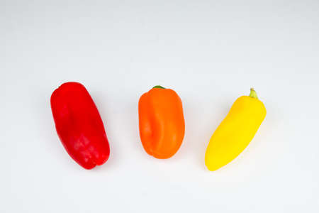 Peppers in different colors on white background. Fresh peppersの写真素材