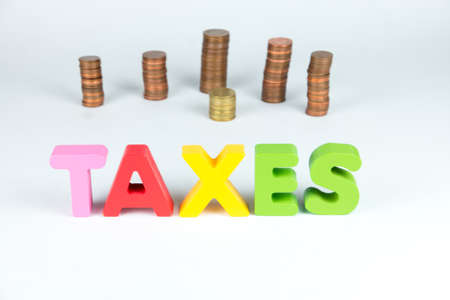 Taxation concept. Tax payment responsibility, every saved Euro is important. Sign taxes with euro coins behind it.の写真素材