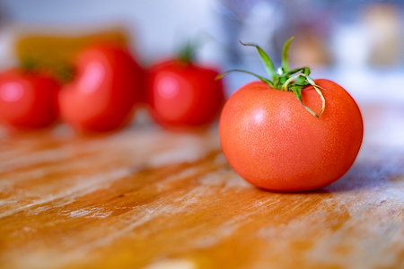 Group of tomatoes on the wooden table in kitchenの写真素材