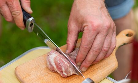 Close-up of men's hands sliced marinated raw meatの写真素材