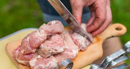 Close-up of men's hands sliced marinated raw meatの写真素材