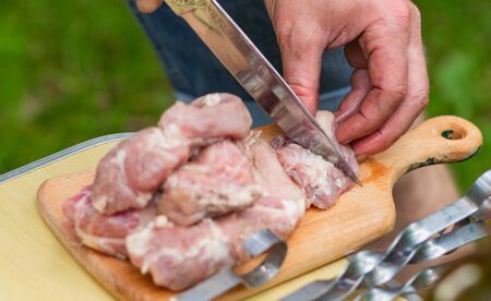 Close-up of men's hands sliced marinated raw meatの写真素材