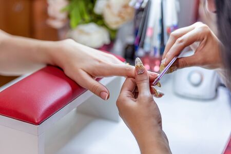 the manicure master saws nails with a nail fileの写真素材