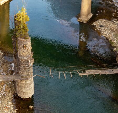 mountain river with clear cold water and old bridgeの写真素材