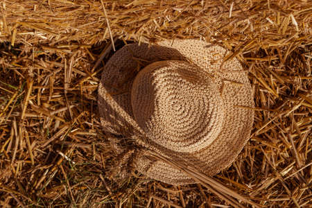 straw hat with ears of wheat on a background of wheat straw