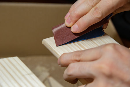 a man sands a wooden board with sandpaper at home, DIYの写真素材