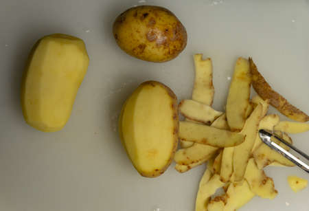 peeled potatoes on the board top viewの写真素材