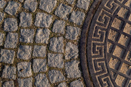 part of the road hatch with Greek ornament on the road made of granite stoneの写真素材