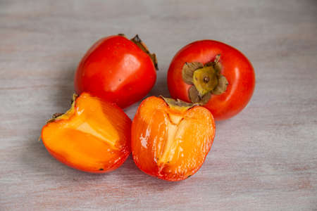 ripe juicy persimmon on a wooden backgroundの写真素材