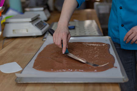 the confectioner spreads the dough with a pastry spatula