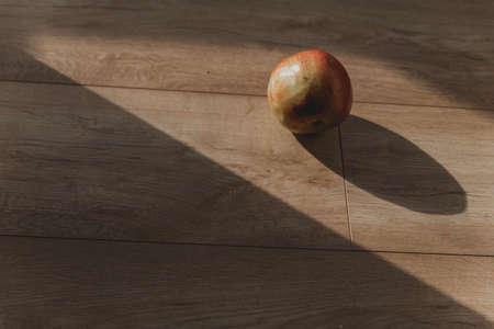 apple on a wooden floor in the sun