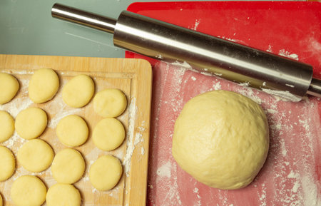 ball of dough cut out circles of dough on the tableの写真素材