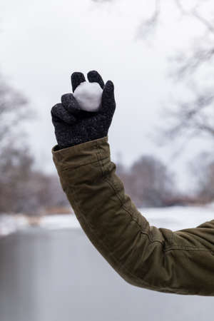 male hand holding snowballs on a winter backgroundの写真素材