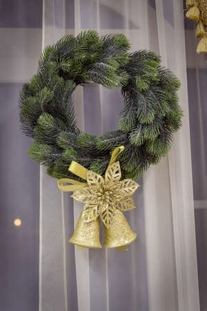 Christmas wreath with golden bells on a white backgroundの写真素材