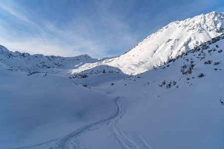 Mountain winter landscape in the Tatras, trail trampled in the snow overlooking the snow-capped mountains in frosty sunny weather Tatras Polandの写真素材