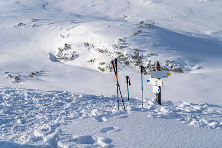 tourist sticks in the snow near the sign high in the mountainsの写真素材