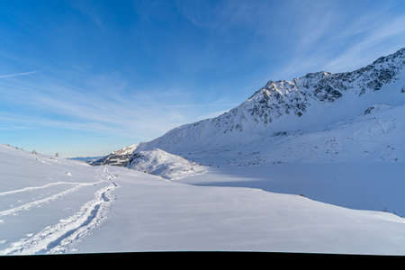 Mountain winter landscape in the Tatras, trail trampled in the snow overlooking the snow-capped mountains in frosty sunny weather Tatras Polandの写真素材