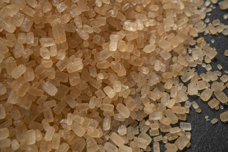 granules of brown sugar macro on a black background