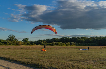 Learn to paraglider, paraglider catching wind flow from the ground in summer warm weather with blue sky and white clouds backgroundの写真素材