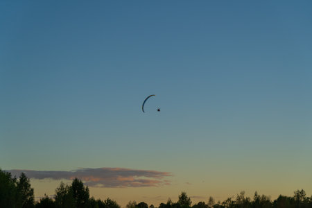 paragliding silhouette of a paraglider in the air against the background of the evening sky at sunsetの写真素材