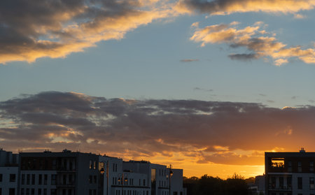 incredible golden sunset with dark clouds in the cityの写真素材