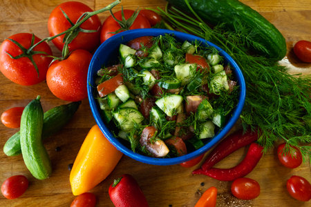 Fresh salad with cucumbers, tomatoes and dill in a blue bowlの写真素材
