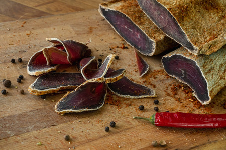Dried beef basturma sliced on a cutting boardの写真素材