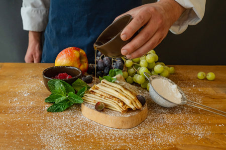 pancakes with fresh berries, honey and mint on a wooden tableの写真素材