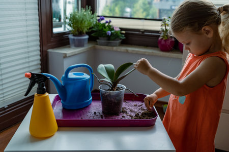 Cute little girl transplanting orchid flower into a new potの写真素材