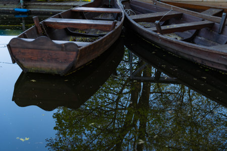 Wooden boats on the lake with reflection of trees in the waterの写真素材