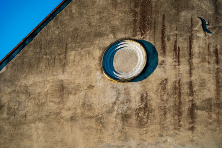 Architectural detail of an old building with a round window.