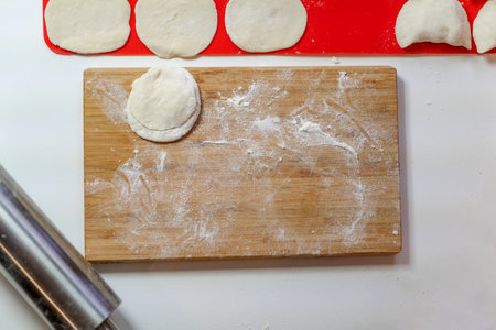 Cooking dumplings on the kitchen table with a rolling pinの写真素材