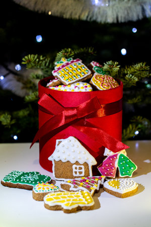 Gingerbread cookies in a red box on the background of a Christmas treeの写真素材