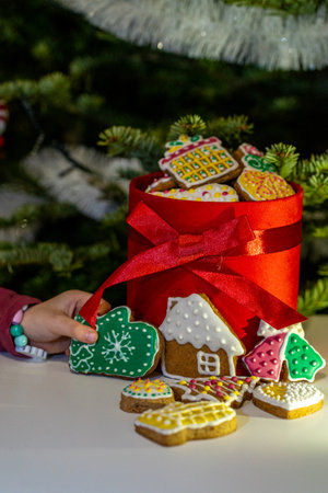 Gingerbread cookies in a red box on the background of a Christmas treeの写真素材