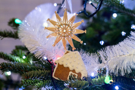 Christmas tree decorated with gingerbread house and golden snowflake, closeupの写真素材