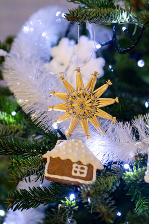 Christmas tree decorated with gingerbread house and golden snowflake, closeupの写真素材