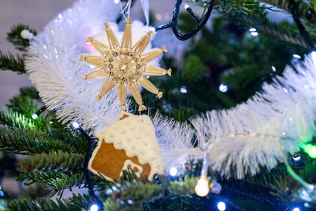Christmas tree decorated with gingerbread house and golden snowflake, closeupの写真素材