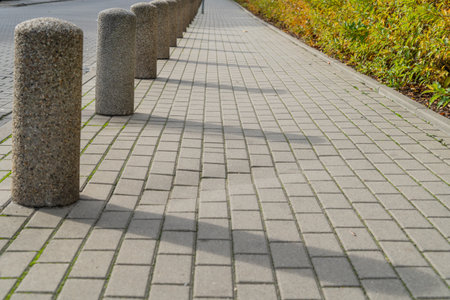 Concrete walkway in the park with gray stone curb and green grassの写真素材