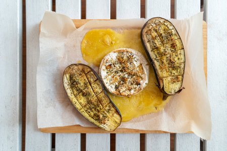 Grilled eggplant with cheese and pineapples on wooden tableの写真素材