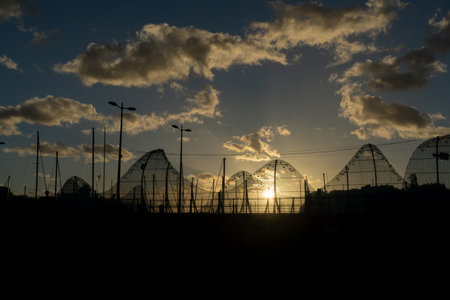 Silhouette of the bridge with people at sunset against the background of the sun Funchal, Madeira, Portugalの写真素材