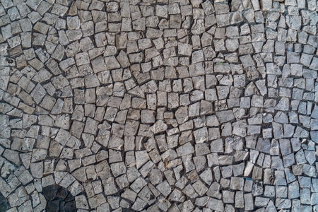 Old cobblestone road texture background on Madeira. Close up of cobblestone pavement background.