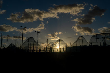 Silhouette of the bridge with people at sunset against the background of the sun Funchal, Madeira, Portugalの写真素材