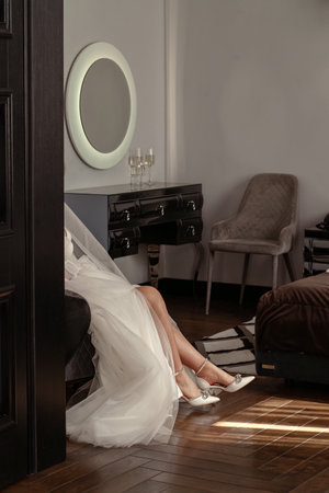 Cropped image of bride putting on high heeled shoes in bedroomの写真素材
