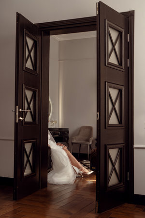 Cropped image of bride putting on high heeled shoes in bedroomの写真素材