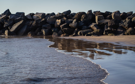 A view of a rocky beach at sunset, with the sea in the background.の写真素材