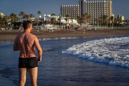 Athletic man running on the beach in the evening.の写真素材