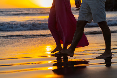 Couple in love walking on the beach at sunset. Honeymoon travel concept.の写真素材