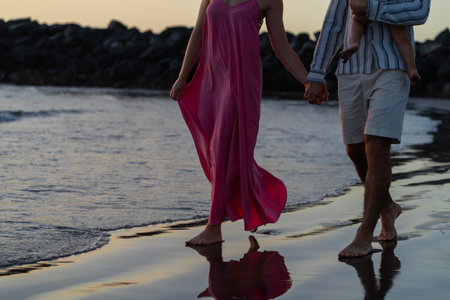 Couple walking on the beach at sunset, holding hands,の写真素材